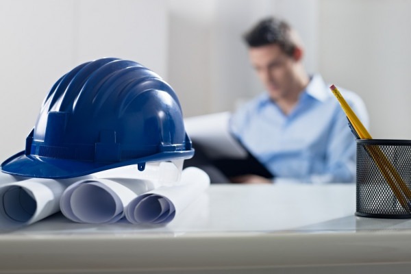 depositphotos_9306608-stock-photo-hardhat-and-blueprint-on-desk